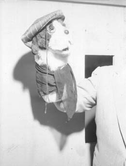 A second view of the same puppet character on the set wall.