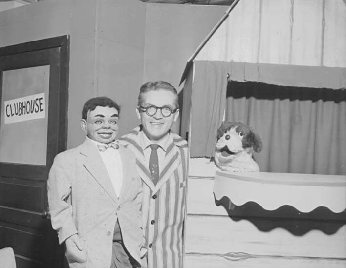 Ted Knight and the ventriloquist's dummy posed together at the CLUBHOUSE door.