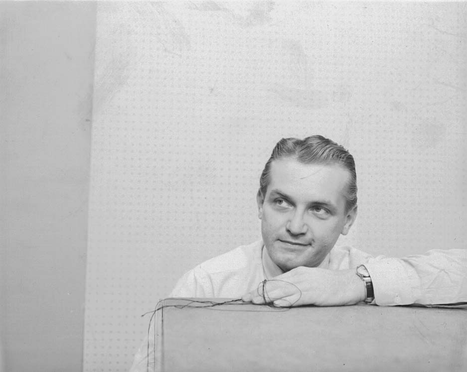 Ted Knight in shirtsleeves resting his arms on a padded ledge, looking off to one side – the full frame of the photograph used at the top of this site.